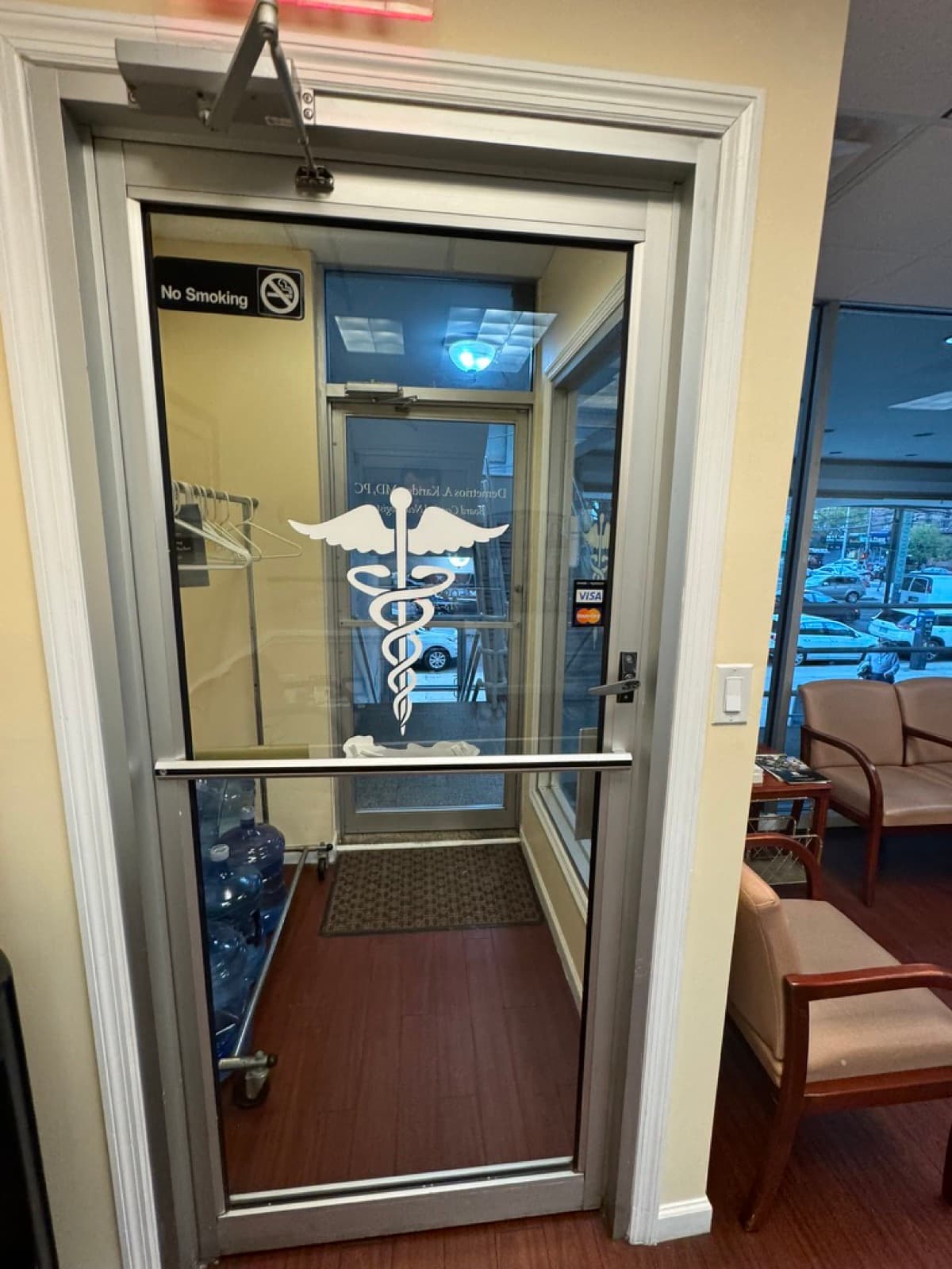Commercial glass storefront door with door closer, installed by Downtown Door in NYC
